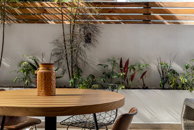 Minimalist metal outdoor table set against a sunlit garden backdrop.