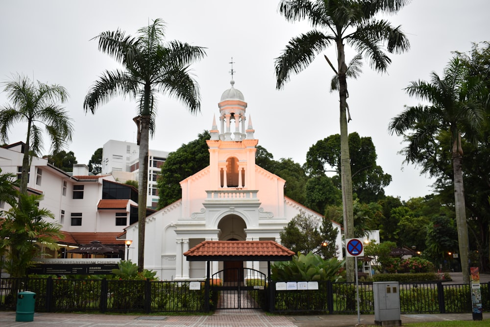 white and brown concrete building near palm trees during daytime