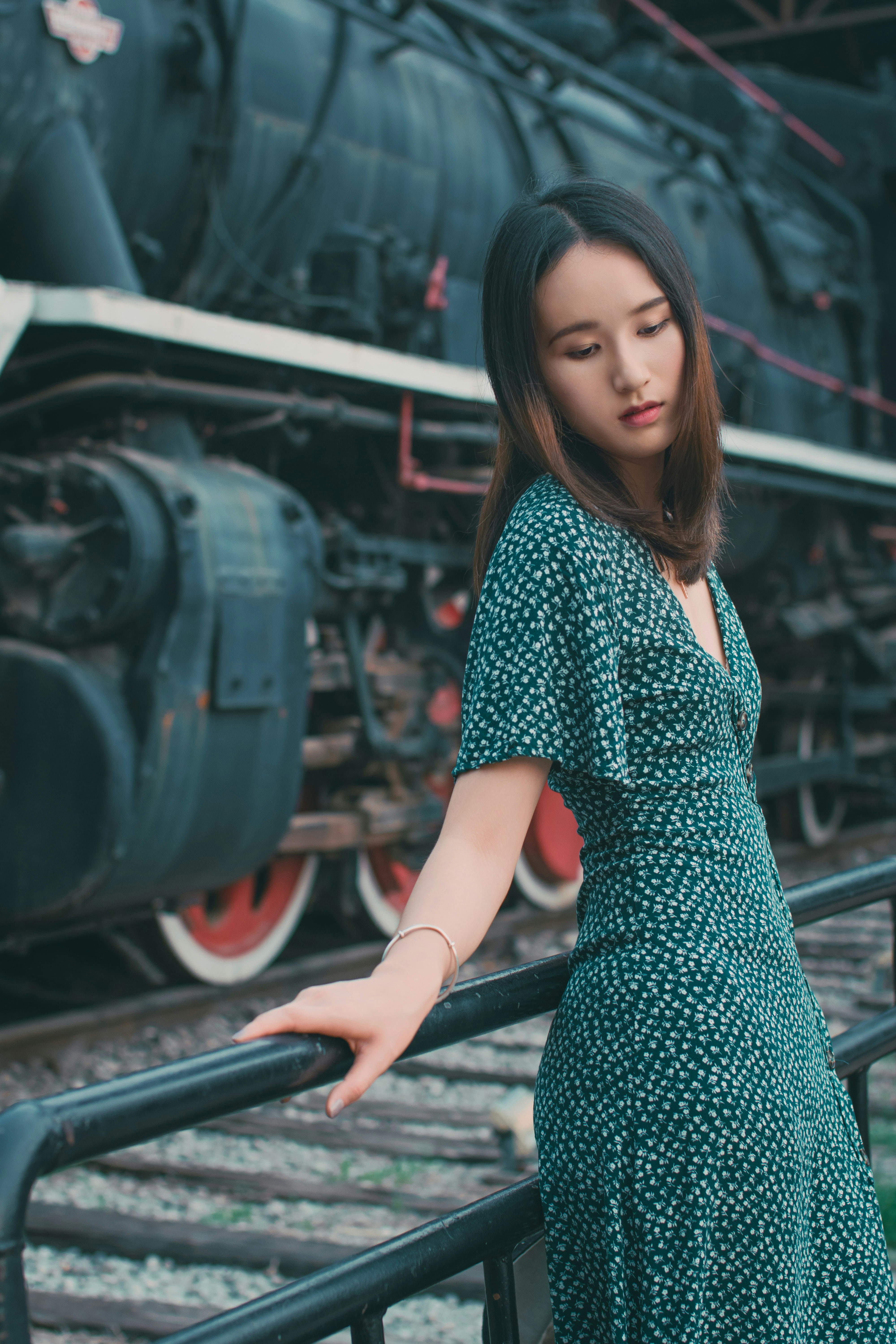 Woman in blue and white polka dot dress standing on train rail photo ...