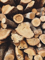 Close-up of freshly cut timber logs stacked neatly, showing rich wood grain.