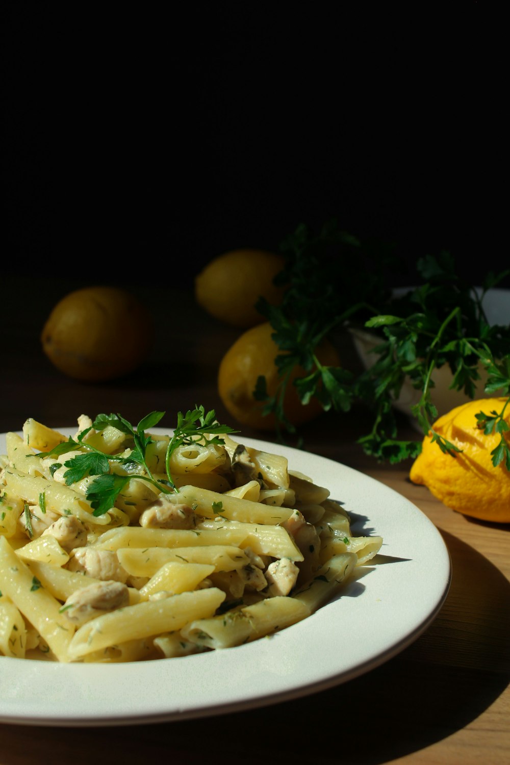 pasta with sliced lemon on white ceramic plate