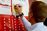 man in white dress shirt holding yellow and white labeled pack