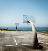 basketball hoop on gray concrete road under blue sky during daytime