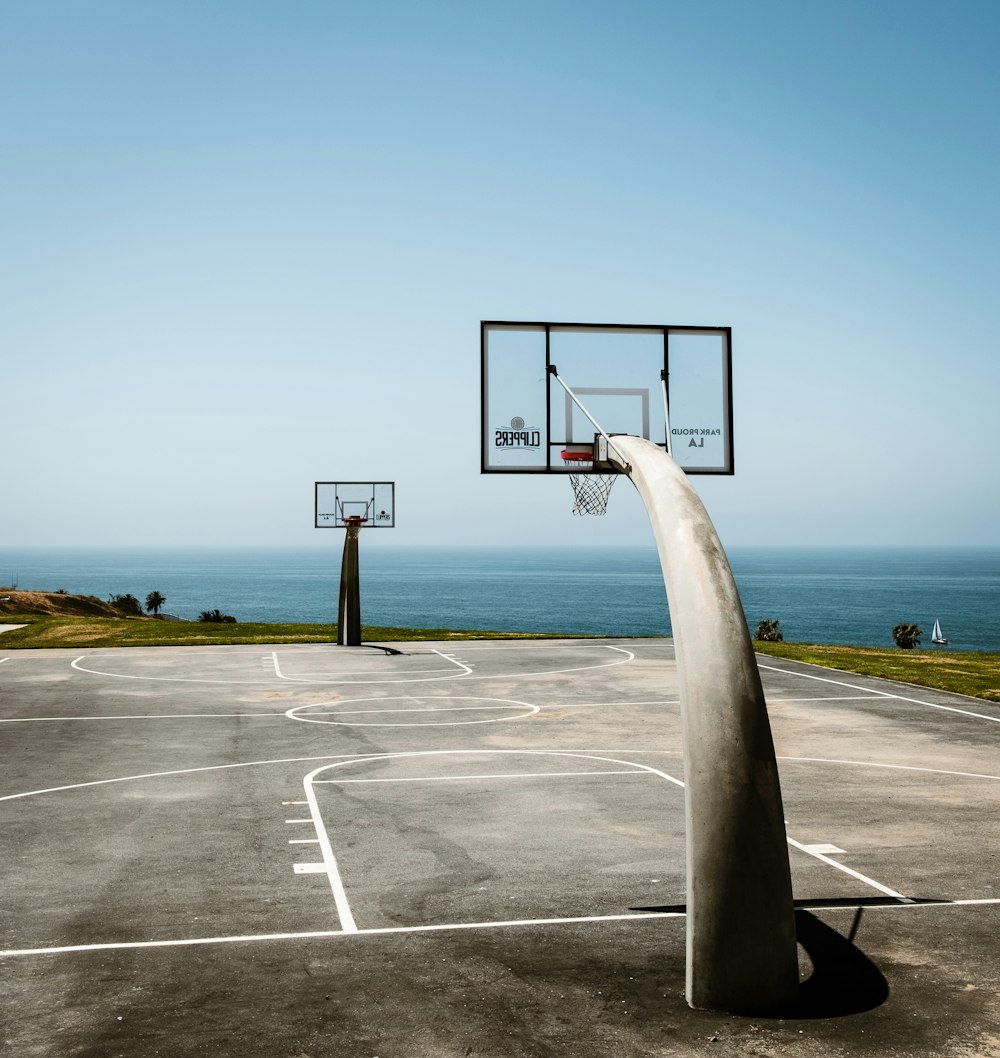 basketball hoop on gray concrete road under blue sky during daytime