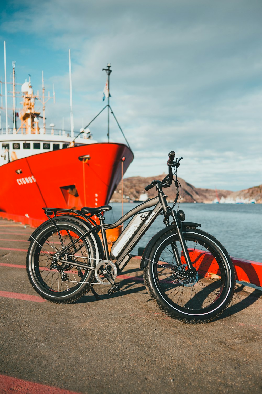 red and black bicycle on beach during daytime