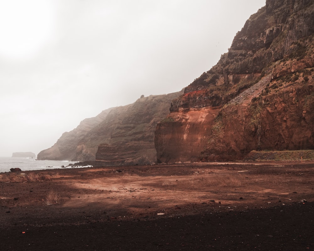 brown rock formation near body of water during daytime