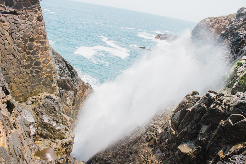 brown rocky shore with ocean waves during daytime