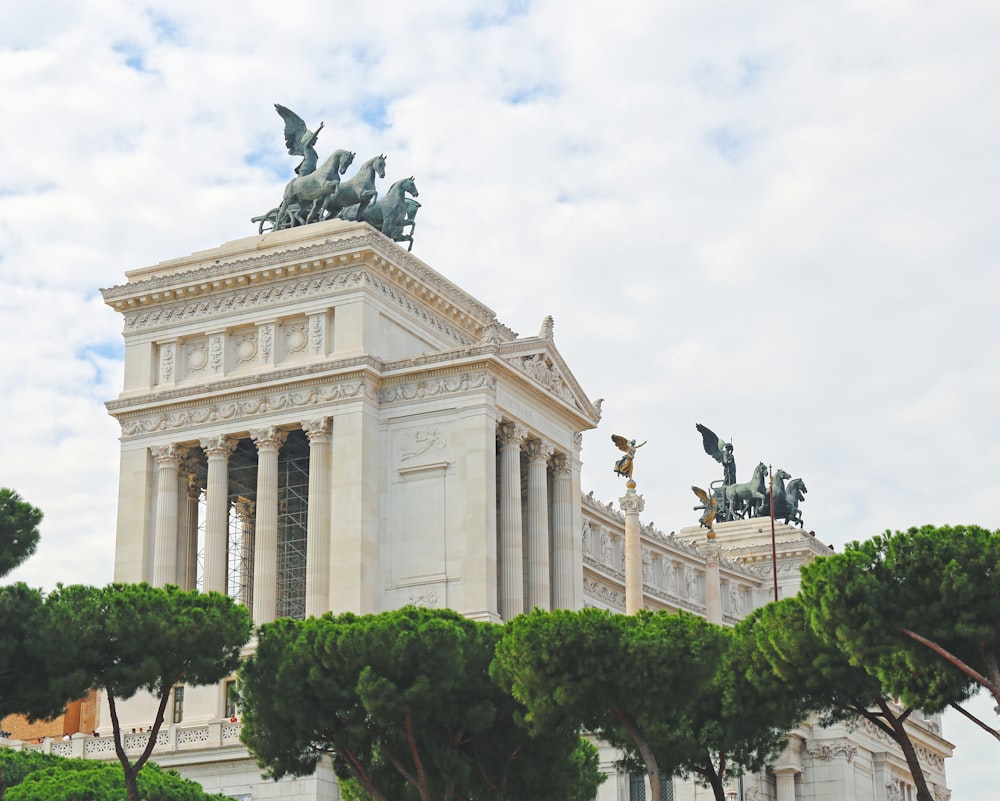 white concrete building with statue on top