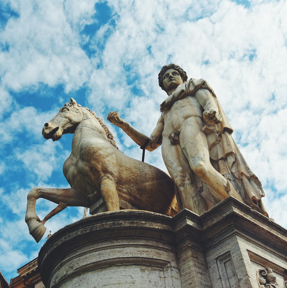 Hombre montando estatua a caballo bajo el cielo azul durante el día