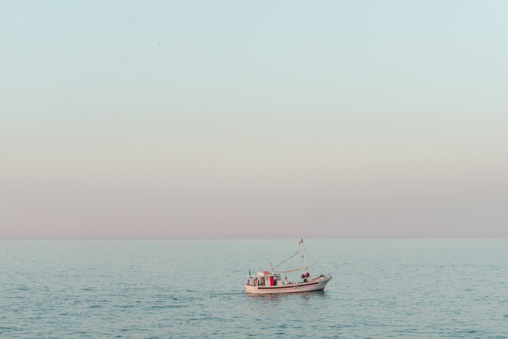 barco vermelho e branco no mar durante o dia