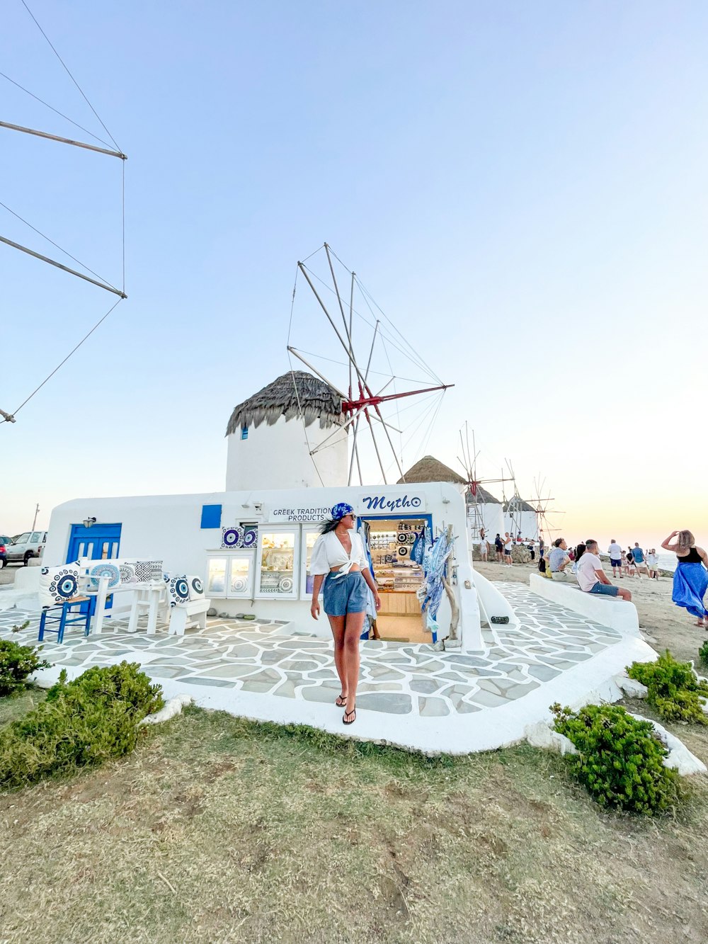 Femme en robe blanche et verte debout sur un sol en béton blanc pendant la journée