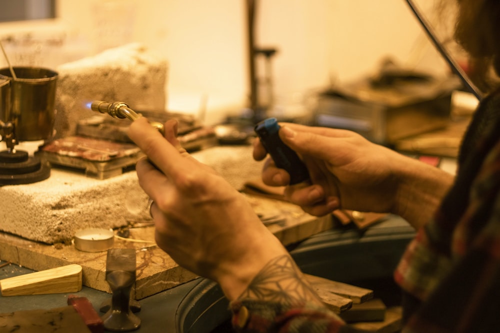 person holding blue and silver hand tool