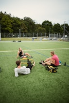 people playing soccer on green grass field during daytime
