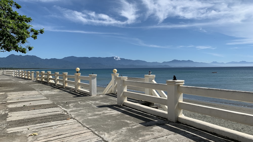 white wooden dock on sea under blue sky during daytime