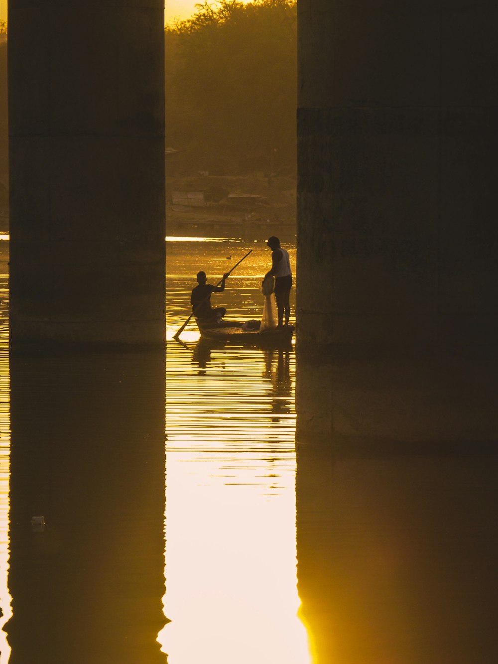silhouette of man and woman on body of water during sunset