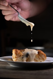person holding stainless steel fork with white cream
