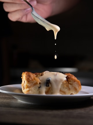 person holding stainless steel fork with white cream