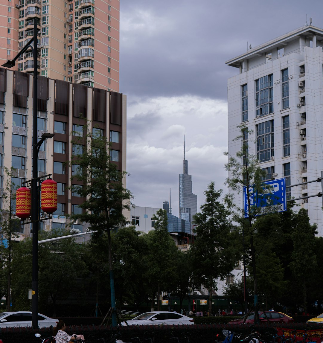 cars parked on side of road near high rise building during daytime