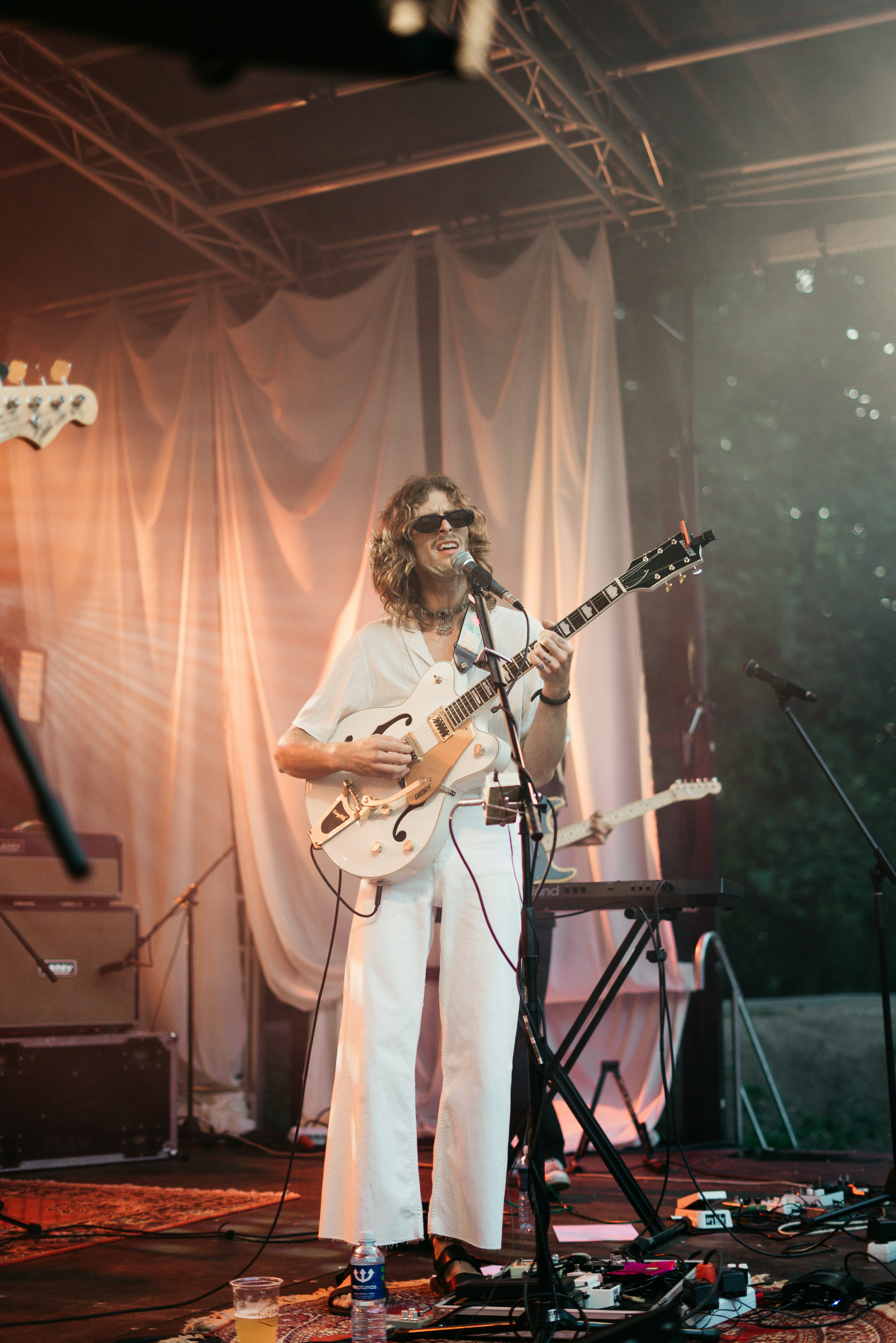 woman in white shirt playing guitar on stage