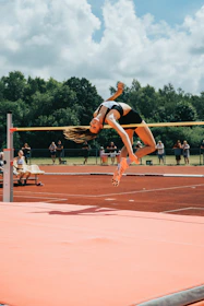 An intense moment of a pole vaulter mid-air during a jump at ICF Chennai venue.