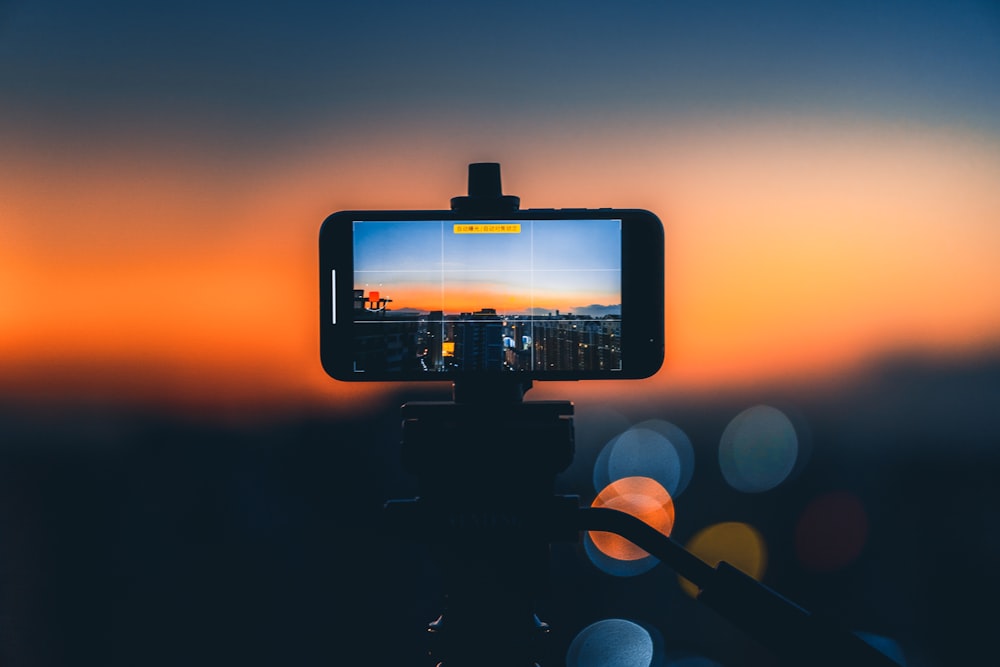 black smartphone taking photo of sunset