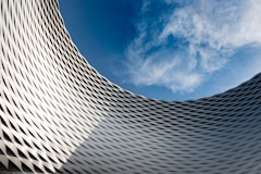 worms eye view of gray building under blue and white sunny cloudy sky