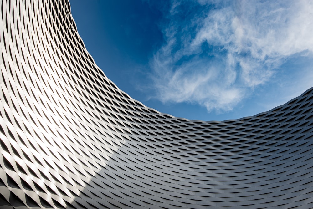 worms eye view of gray building under blue and white sunny cloudy sky