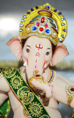 Lord Ganapati in gold and green crown