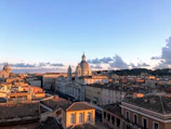 A panoramic view of a historic cityscape bathed in golden hour light.