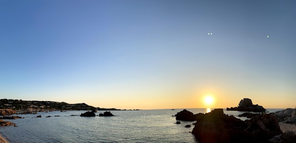 A serene Mediterranean coastline at sunrise, highlighting calm waters and natural beauty.