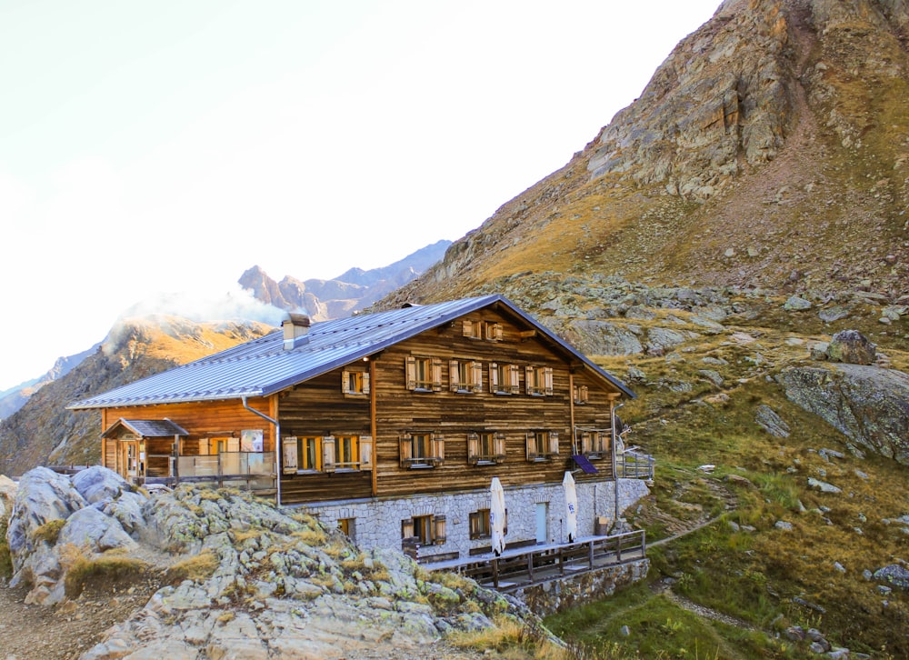 brown wooden house near mountain during daytime
