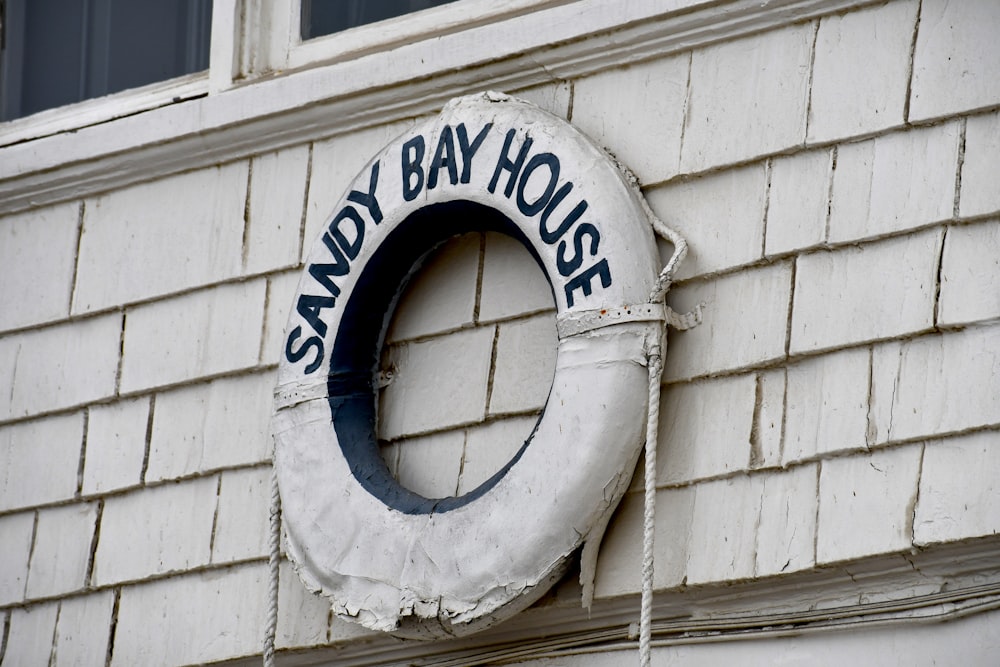 Un letrero en el costado de un edificio que dice Sandy Bay House