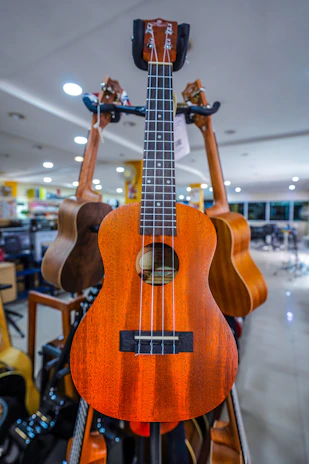 A vibrant ukulele with colorful strings displayed on a cozy studio shelf filled with music sheets.