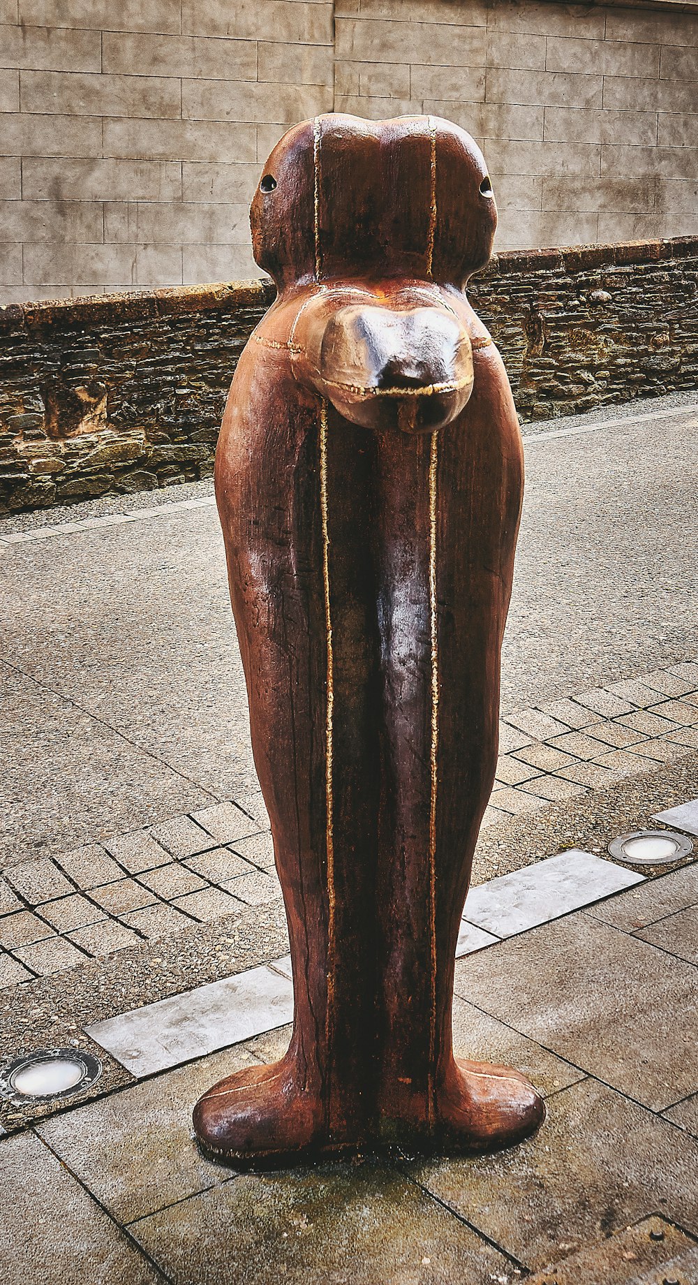 Estatua de madera marrón sobre piso de concreto gris