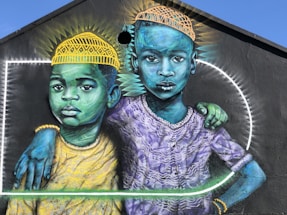 man in yellow and blue hat beside woman in yellow and green dress painting