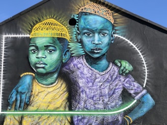 man in yellow and blue hat beside woman in yellow and green dress painting