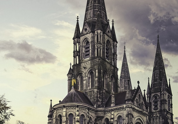 grey concrete church under white clouds during daytime