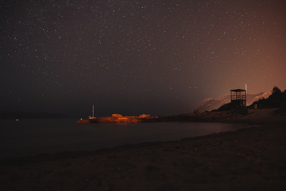 silhouette of person standing on rock formation during night time