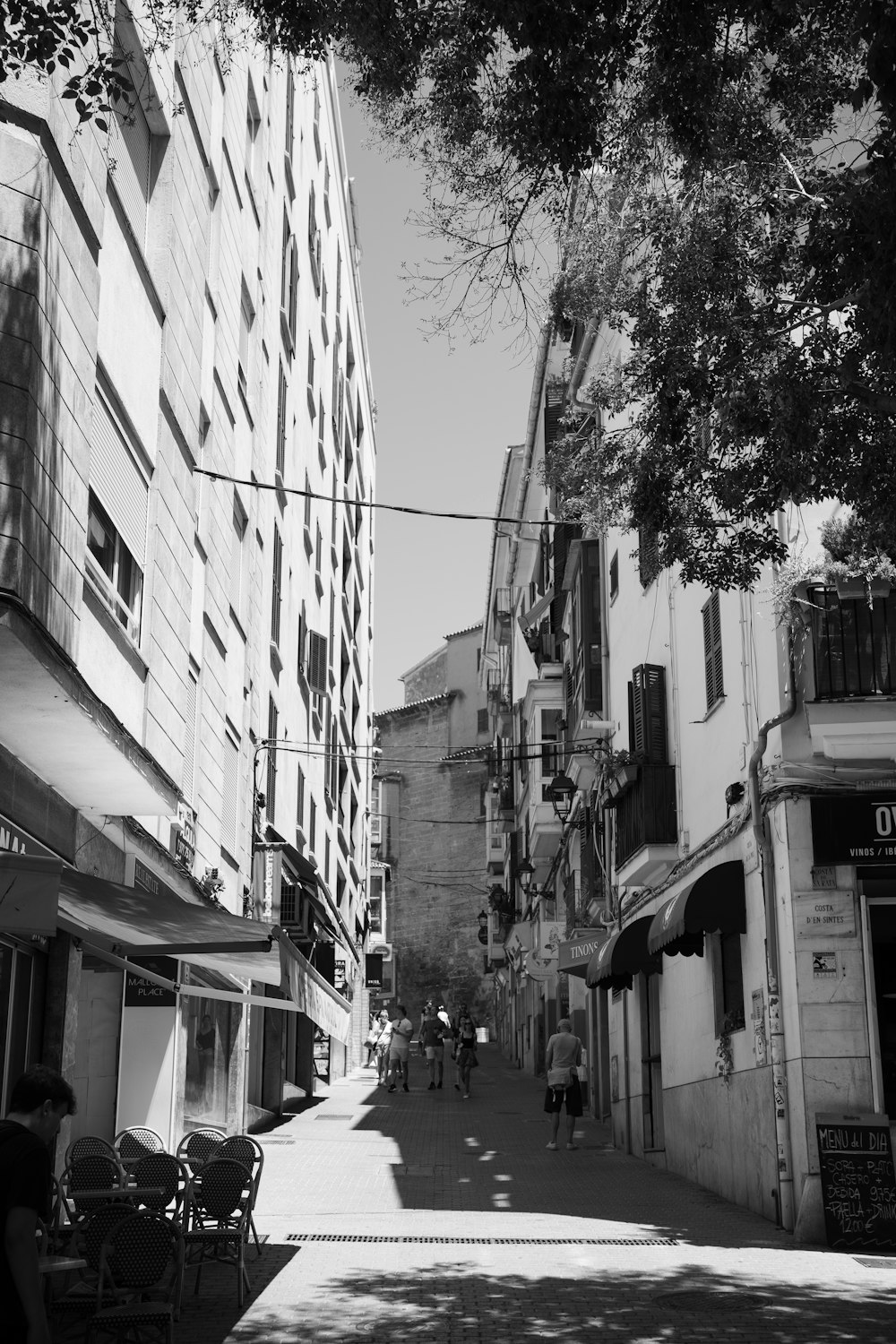 grayscale photo of cars parked beside building