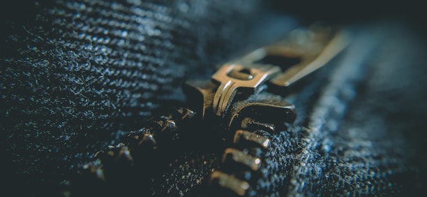 Close-up of hands adjusting the zipper on a Lumina Apparel jacket, highlighting the fine craftsmanship.