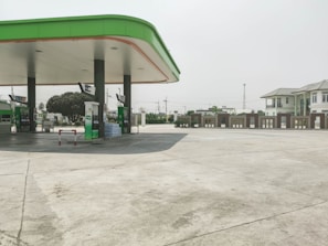 A petrol pump dealer using a checklist on a tablet in a clean, modern fuel station.