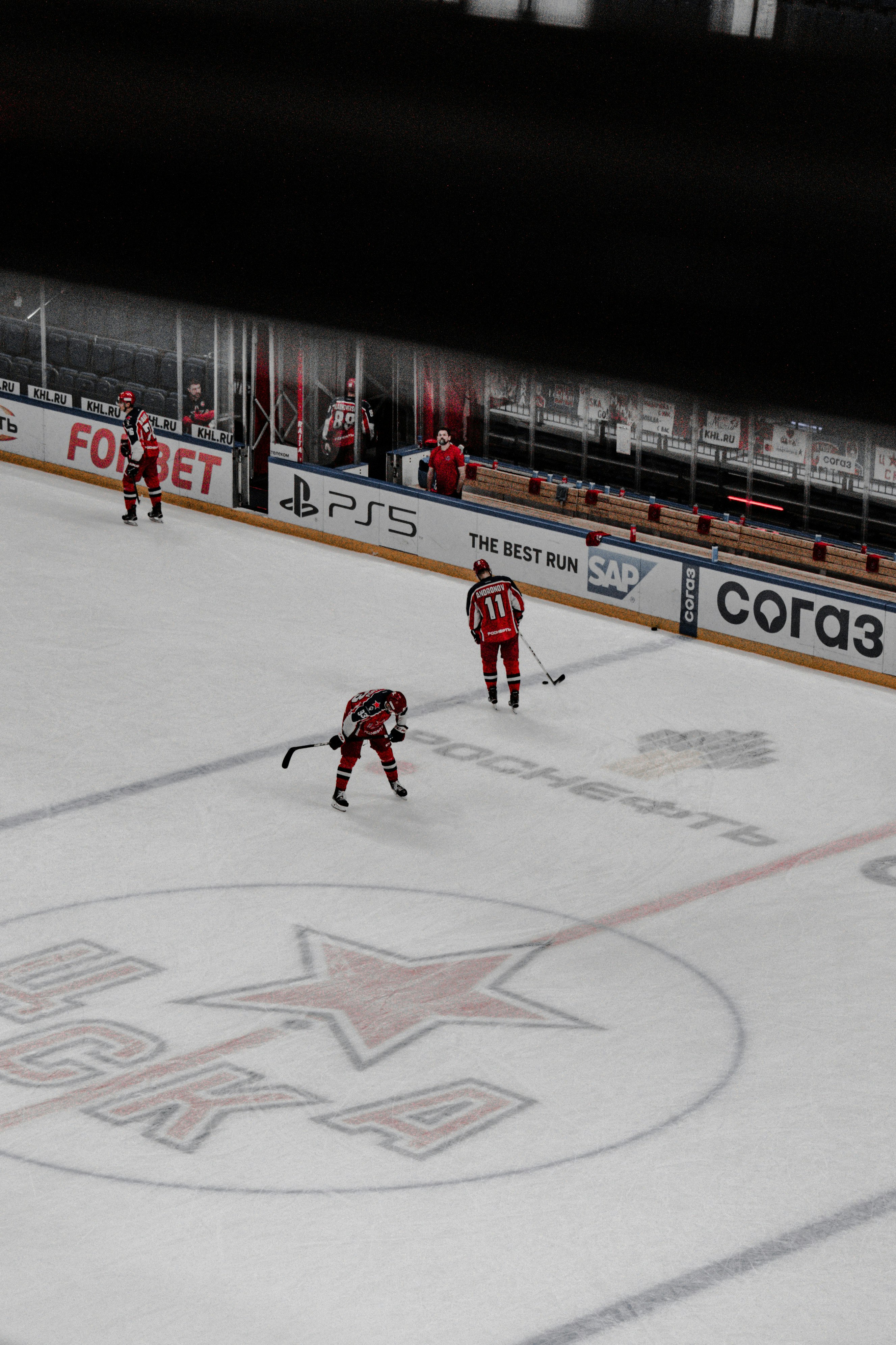 man in red jersey shirt playing hockey