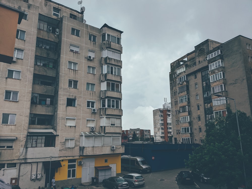 Auto parcheggiate di fronte all'edificio in cemento marrone durante il giorno