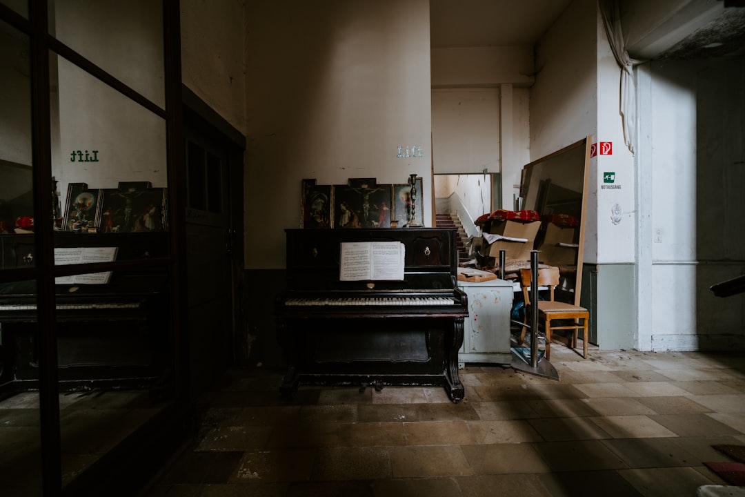 black upright piano near white wall