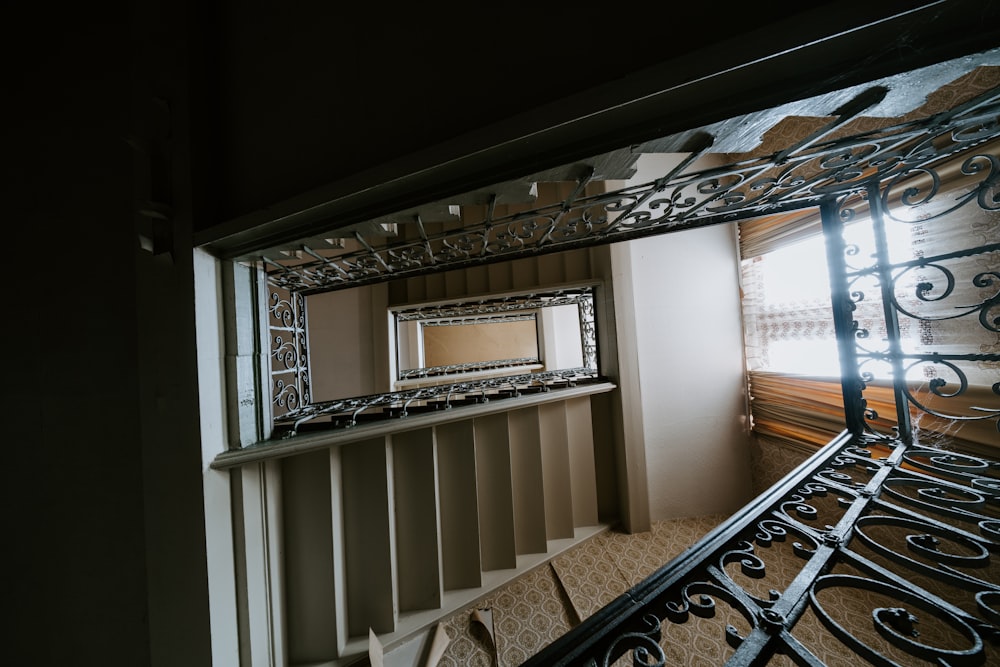 brown wooden staircase near white window blinds