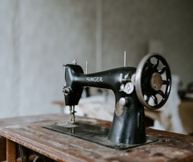 black sewing machine on brown wooden table