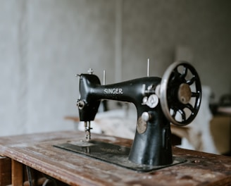 black sewing machine on brown wooden table