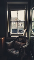 Cozy armchair placed near a large window overlooking the city.