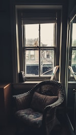 A cozy corner in the sunny room showing a reading chair near the window overlooking the city.
