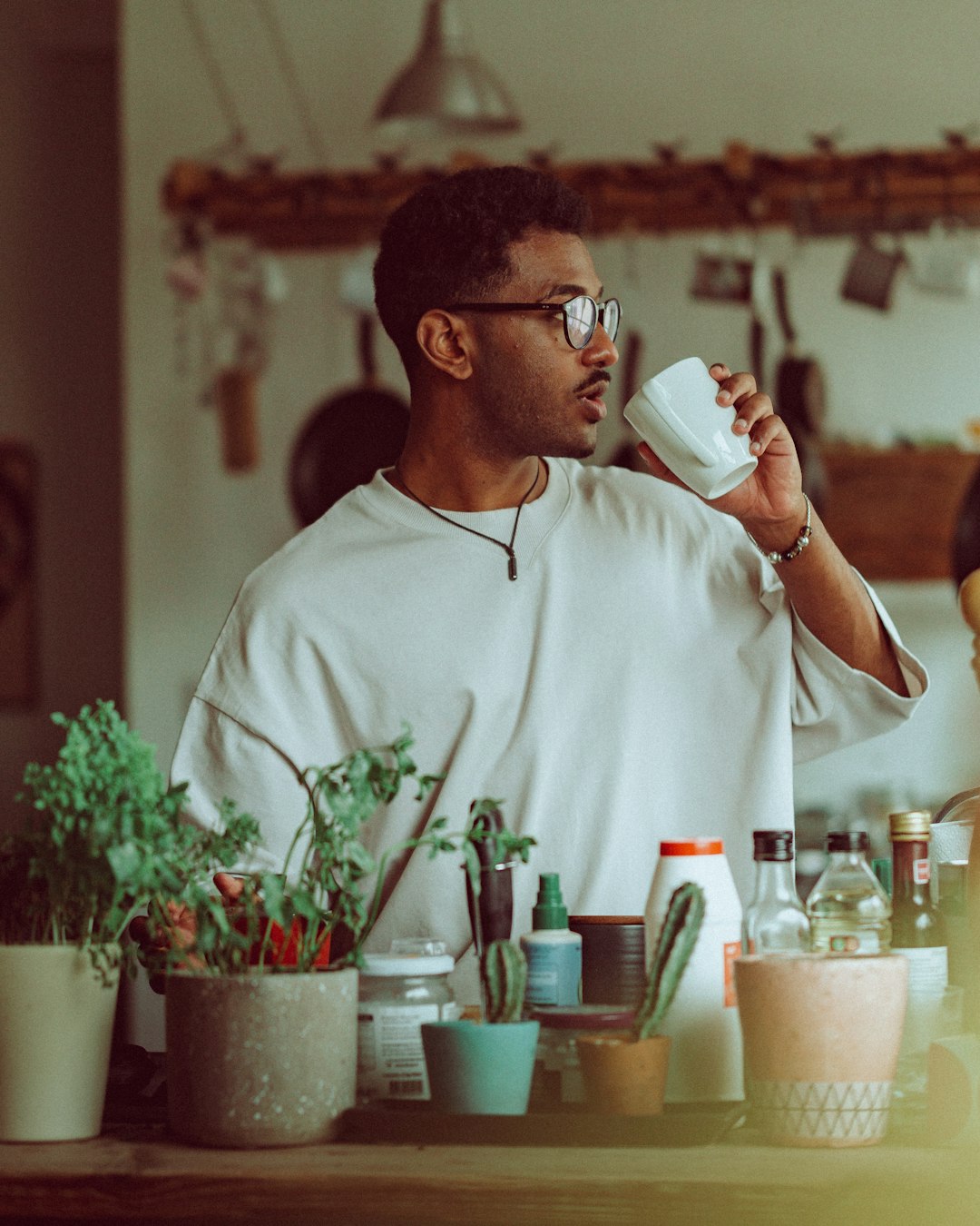 man in white crew neck t-shirt holding white ceramic mug